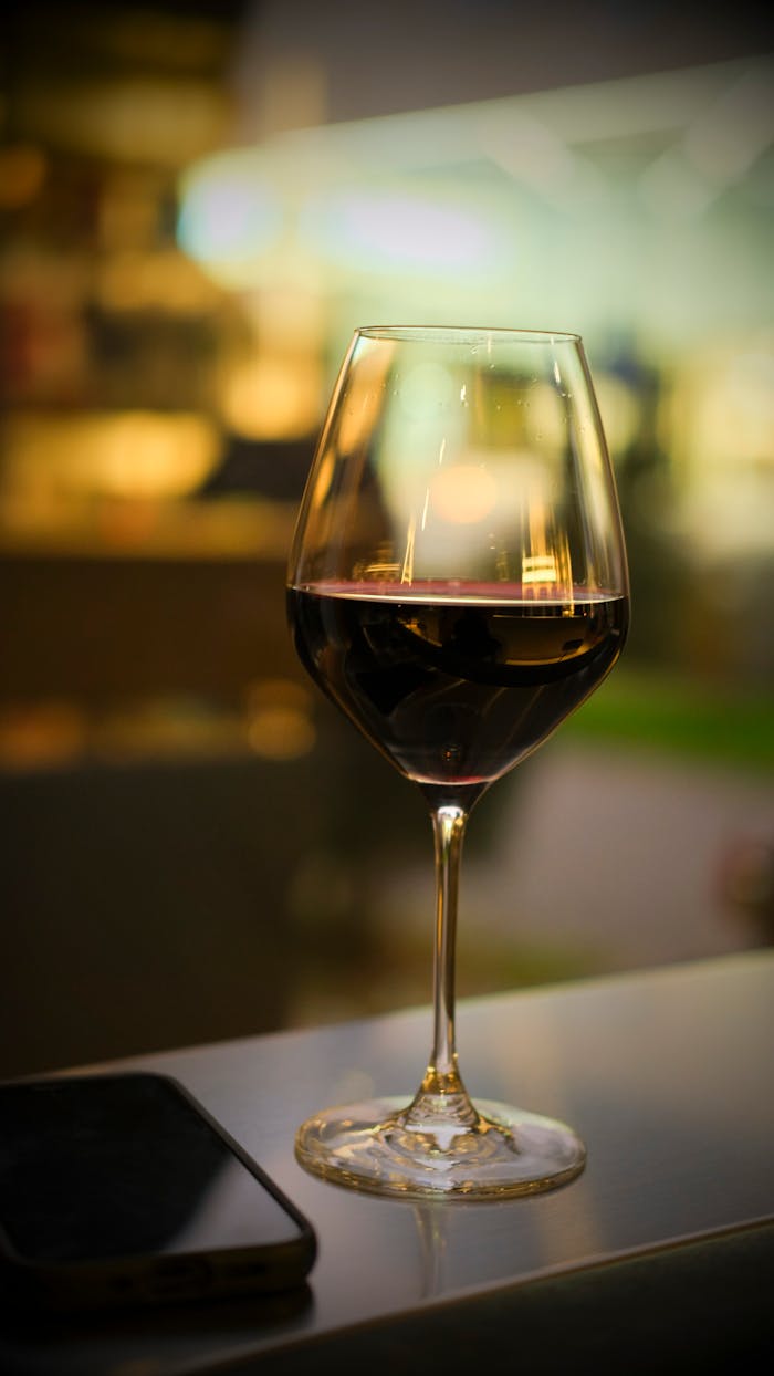 A sophisticated glass of red wine on a café table in Bratislava, capturing the city's vibrant nightlife atmosphere.